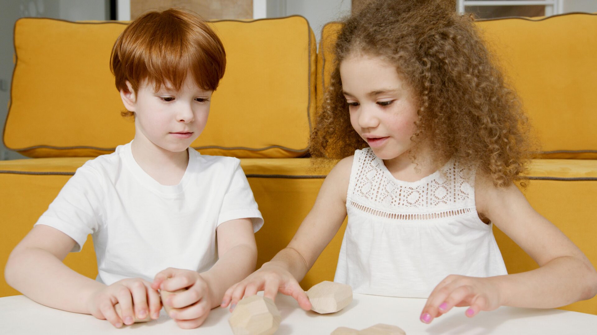 Two children having fun with wooden toys indoors, fostering creativity and play.
